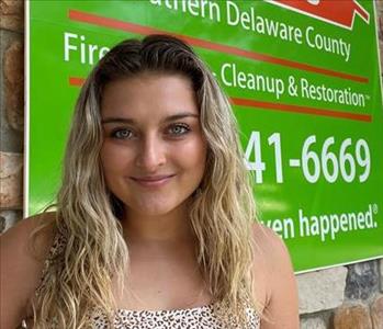 young woman in front of a SERVPRO Building