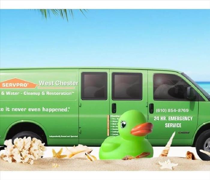 green SERVPRO truck with a beach scene background