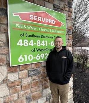 SERVPRO employee in front of franchise poster